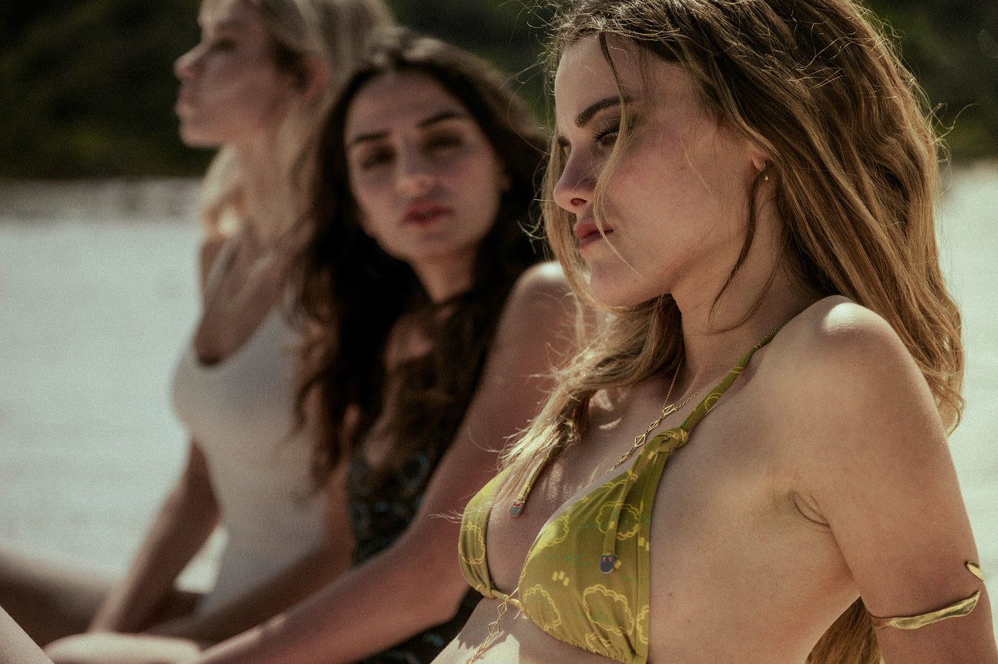 girls staring at the sea wearing noodle beachwear white, black and yellow-green costumes from 2024 summer collection called The Noodle Splash