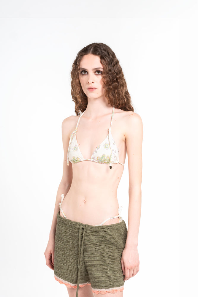 modella su sfondo bianco che indossa il bikini Noodle Beachwear Ellie e il pantaloncino Nala di colore verde militare dalla collezione estiva del 2025 Noodle Mirage
model wearing a knitted shorts miltary green called Nala from the Noodle Beachwear 2025 Noodle Mirage collection 