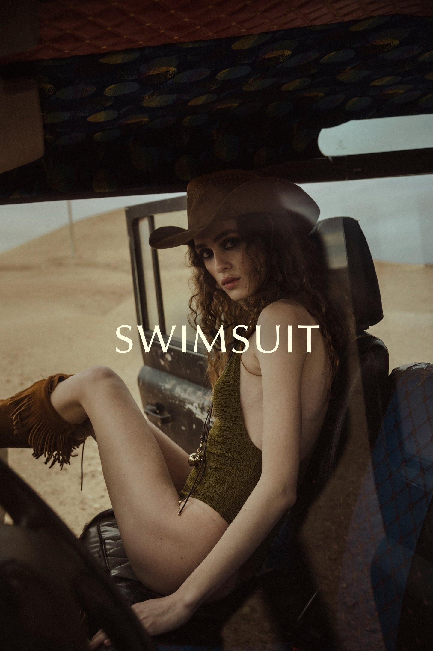 girl sitting on a land rover defender looking at the camera wearing a beautful olive green swimsuit called Sanaa by Noodle Beachwear's 2025 Summer Collection called Noodle Mirage