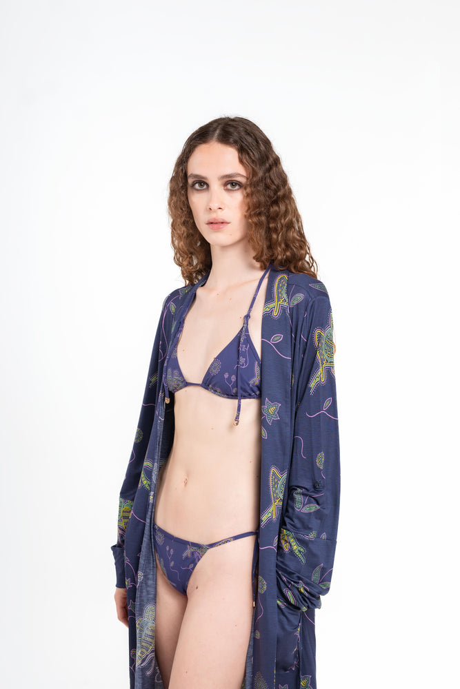 donna indossa tuyo kimono blu notte con stampa pappagalli colorati con texture a mosaico di Noodle Beachwear dalla collezione 2025 estiva Noodle Mirage

girl wearing tuyo kimono printed dark blue with print of colorful parrot and texture